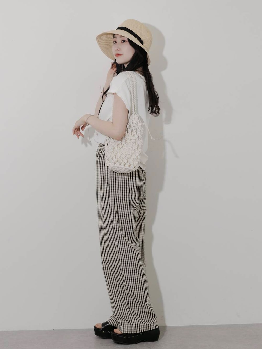 ホワイト系のTシャツ/カットソー、ホワイト系のハンドバッグ、ブラック系のサンダルを着用したレディースの春コーディネートの2枚目の写真