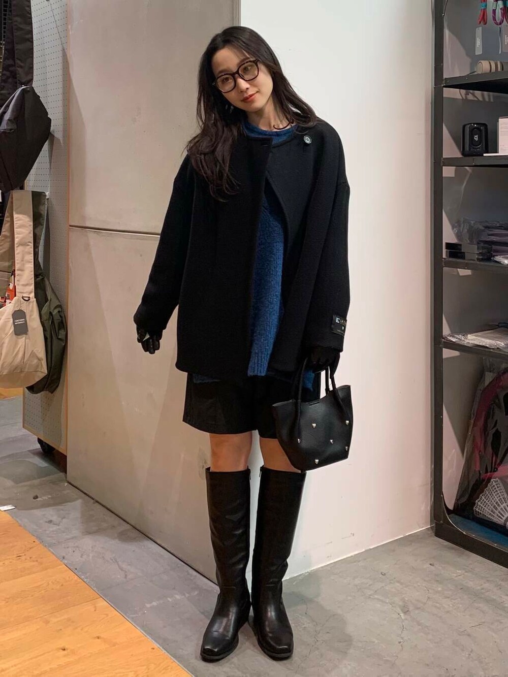 ブラック系のブーツ、ブラック系のその他パンツ、ブラック系のその他アウターを着用したレディースの冬コーディネートの6枚目の写真