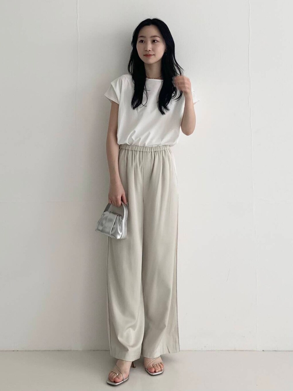 ベージュ系のその他パンツ、シルバー系のハンドバッグ、ホワイト系のTシャツ/カットソーを着用したレディースの春コーディネートの3枚目の写真