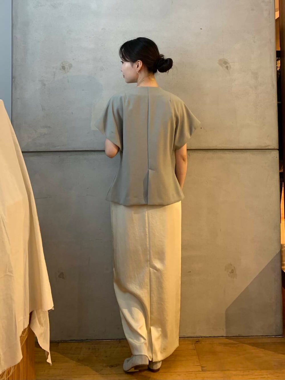 ホワイト系のスカート、ブラウン系のバレエシューズ、グレー系のベストを着用したレディースの秋コーディネートの5枚目の写真