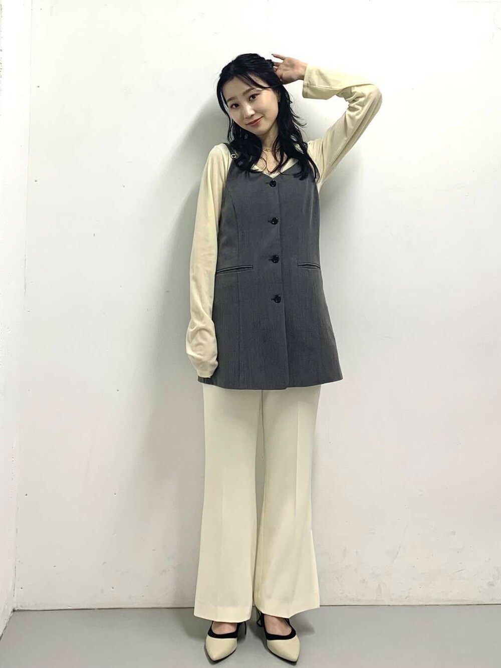 グレー系のチュニック、ホワイト系のパンプス、ホワイト系のTシャツ/カットソーを着用したレディースの秋コーディネートの2枚目の写真