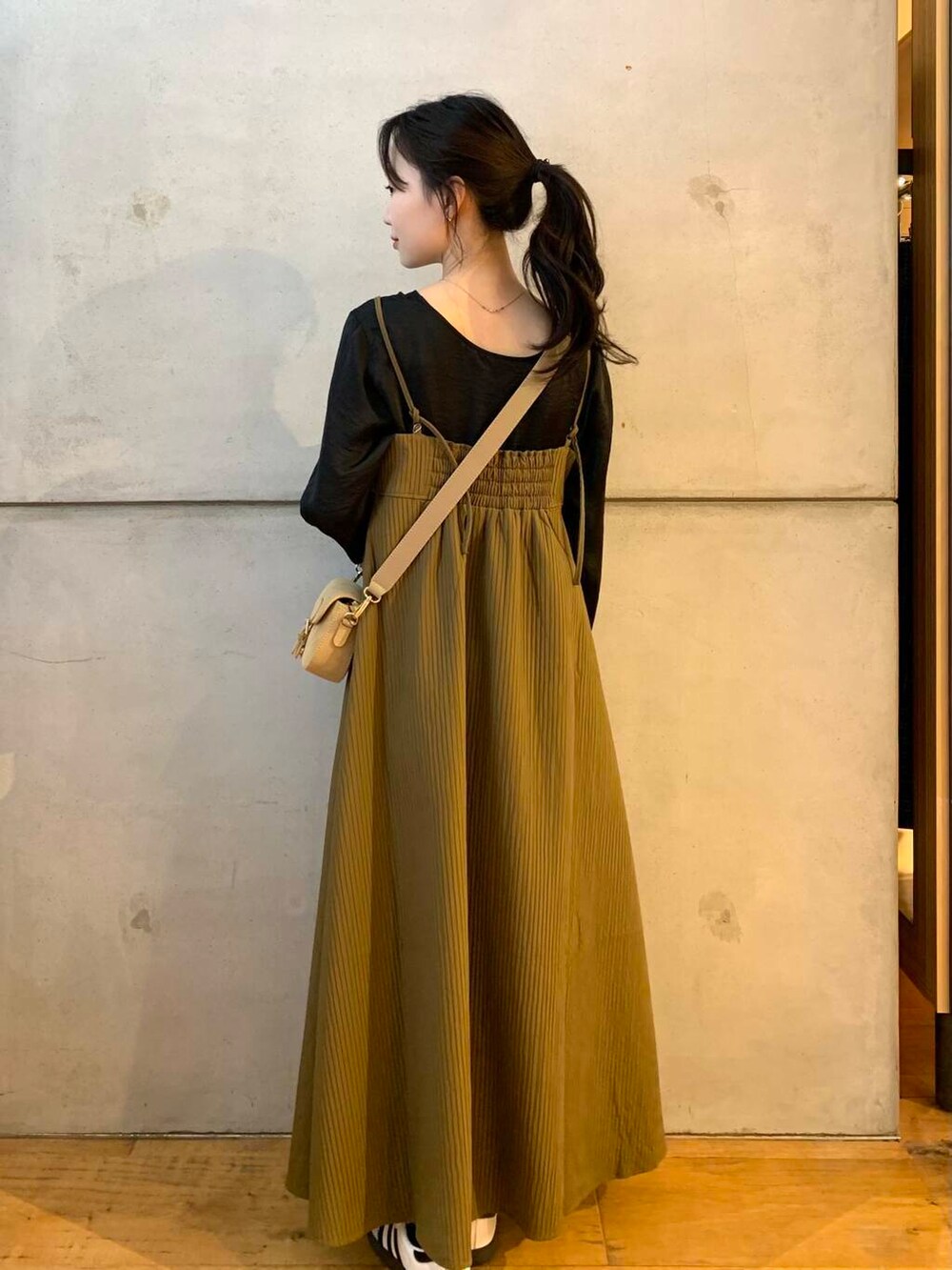 ベージュ系のショルダーバッグ、ホワイト系のスニーカー、ブラウン系のワンピースを着用したレディースの夏コーディネートの6枚目の写真