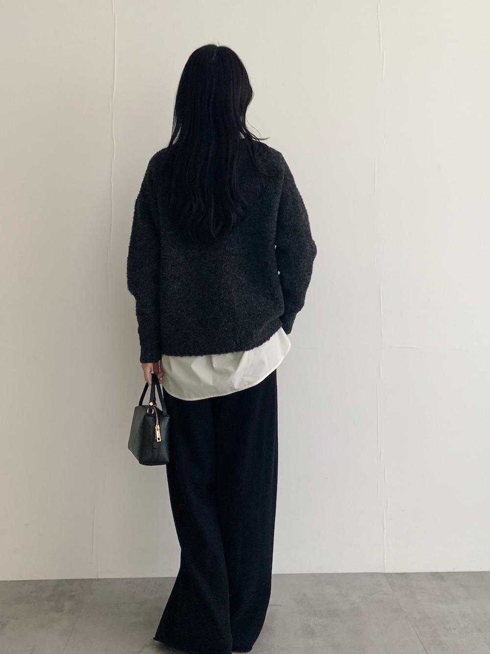 グレー系のニット/セーター、ホワイト系のシャツ/ブラウス、ブラック系のその他パンツを着用したレディースの秋コーディネートの5枚目の写真