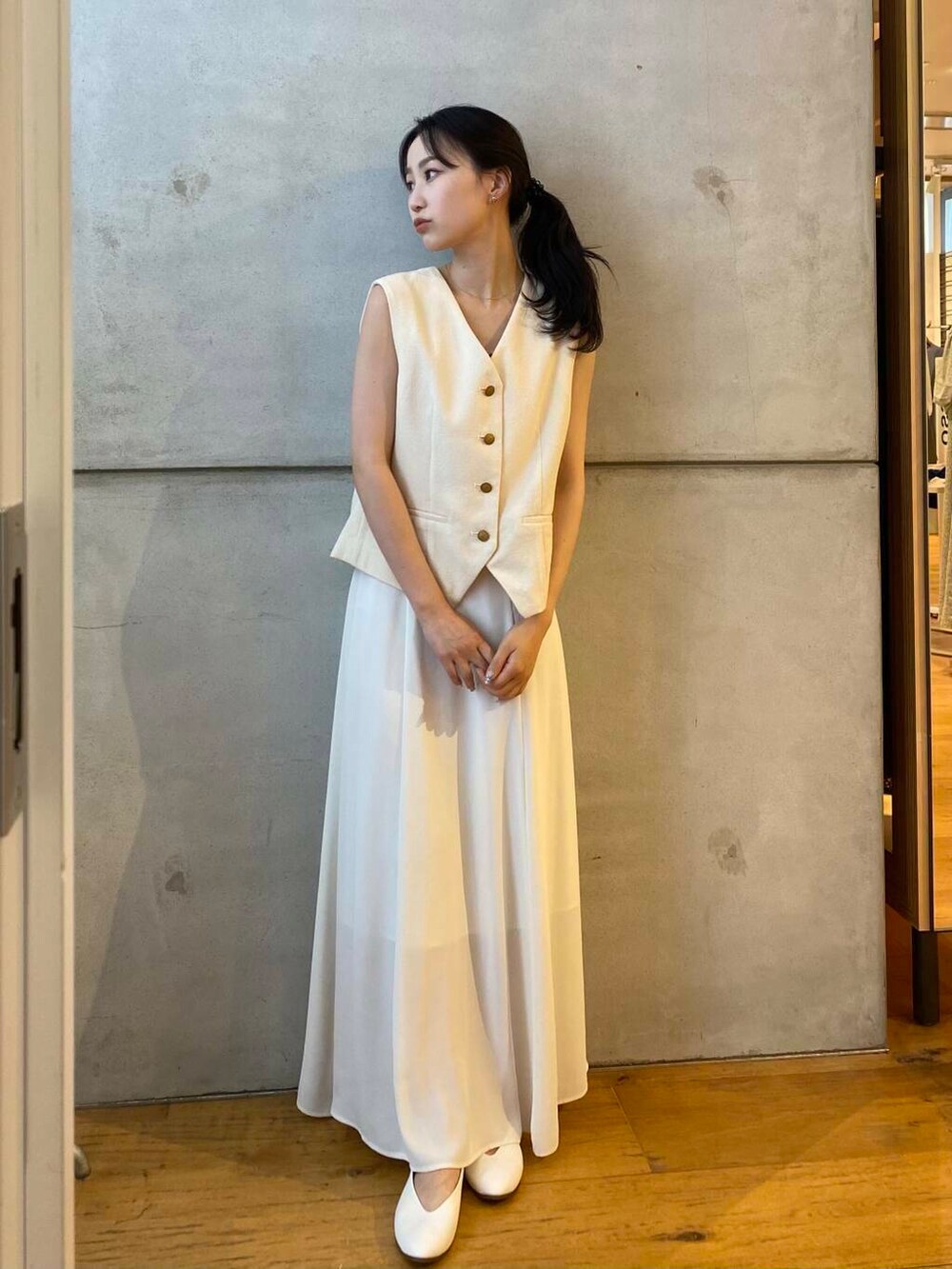 ホワイト系のパンプス、ホワイト系のベスト、ホワイト系のスカートを着用したレディースの夏コーディネートの3枚目の写真