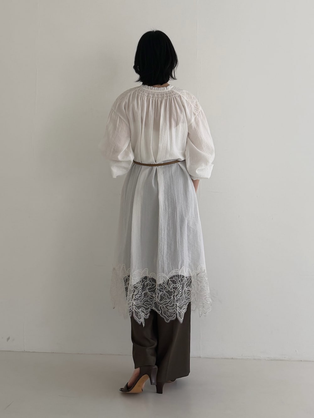 ホワイト系のワンピース、ブラウン系のその他パンツを着用したレディースの冬コーディネートの3枚目の写真