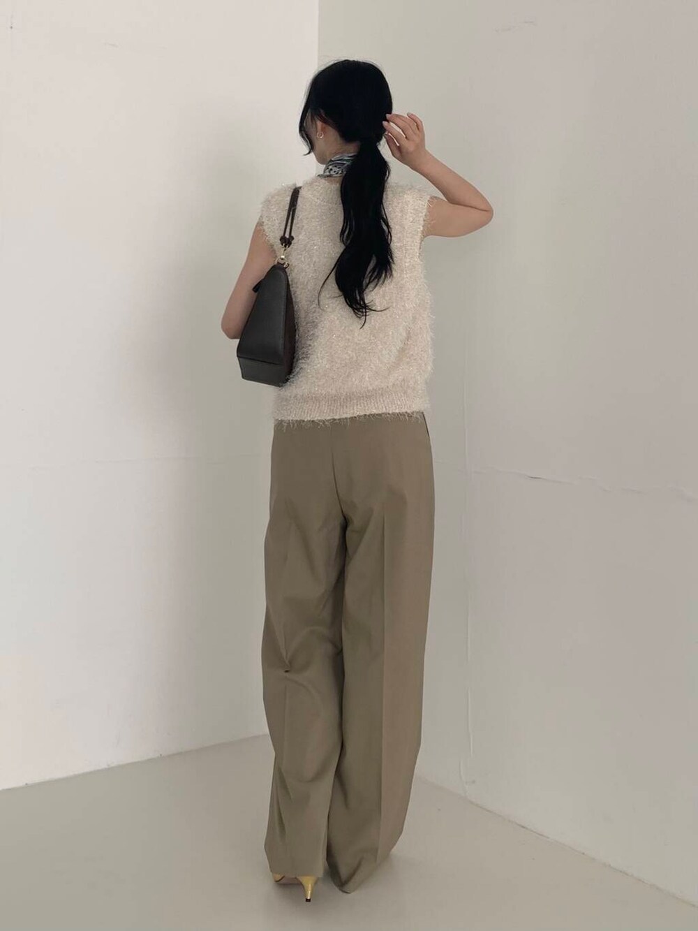ベージュ系のその他パンツ、ホワイト系のベスト、ブラウン系のショルダーバッグを着用したレディースの夏コーディネートの4枚目の写真