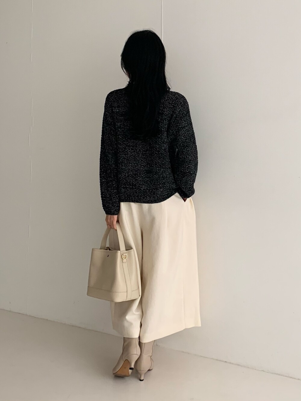 ブラック系のカーディガン/ボレロ、ホワイト系のその他パンツ、ホワイト系のハンドバッグを着用したレディースの秋コーディネートの3枚目の写真