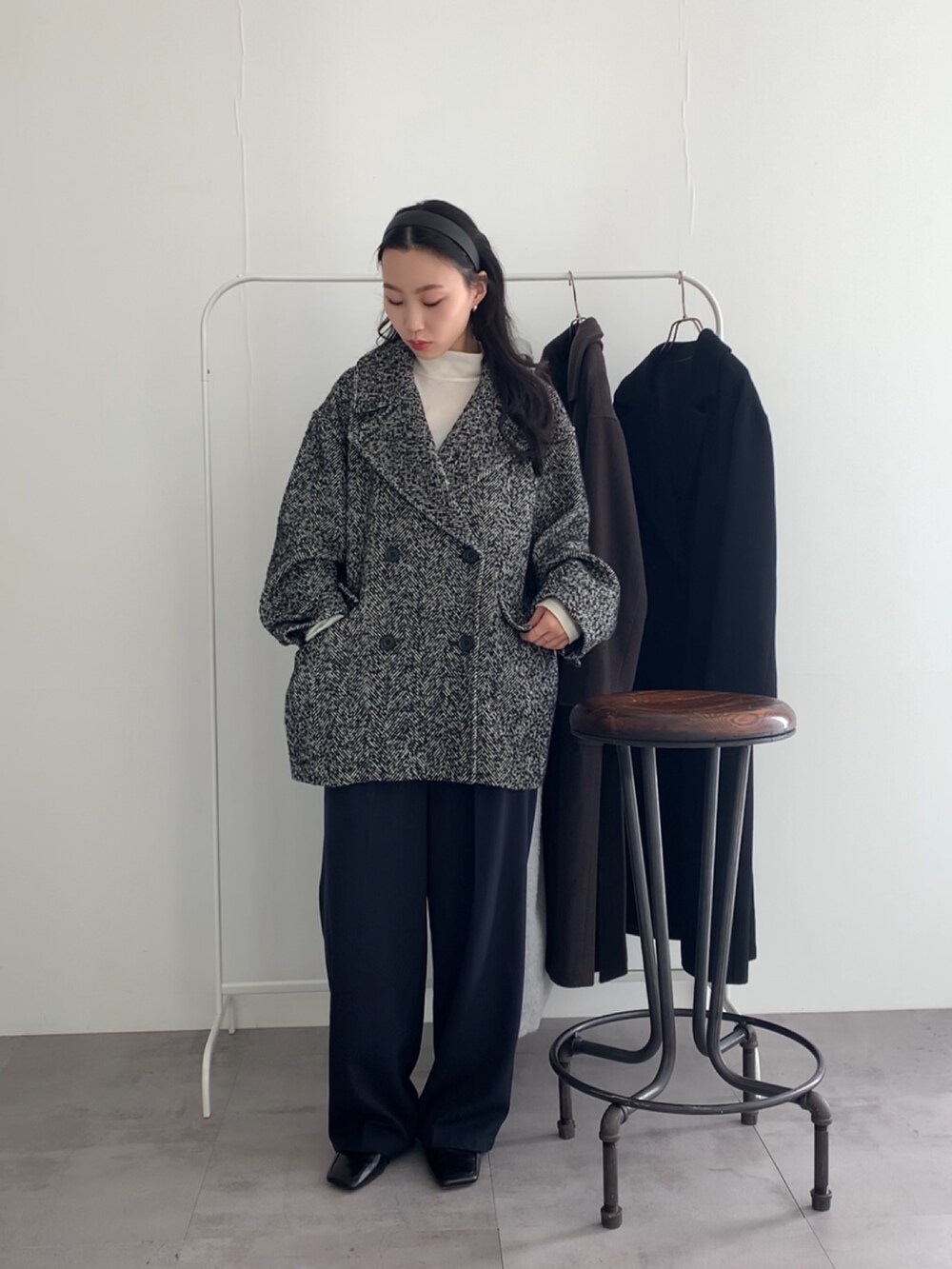 ブルー系のその他パンツ、ブラック系のピーコート、ホワイト系のTシャツ/カットソーを着用したレディースの冬コーディネートの2枚目の写真