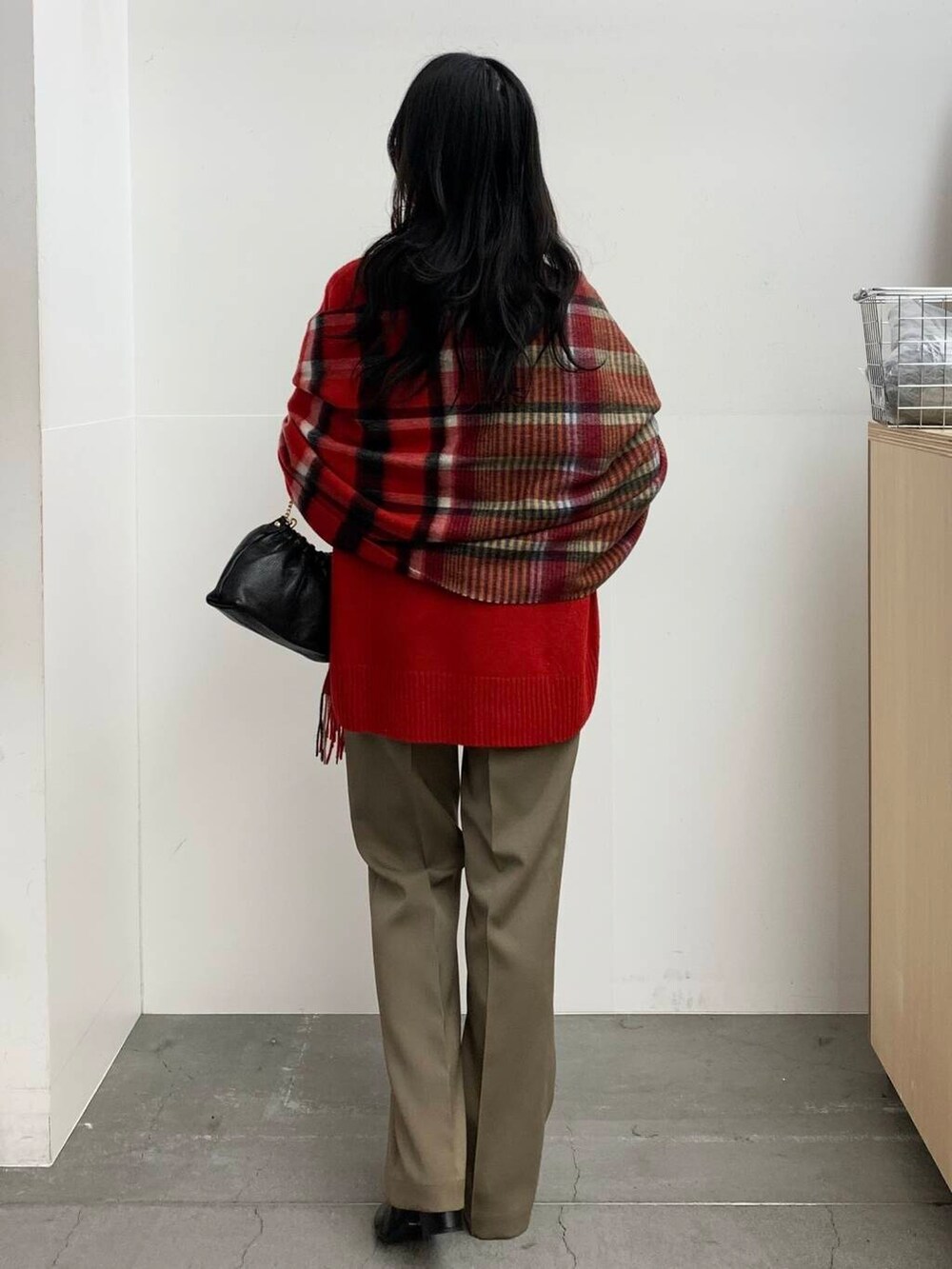 ブラック系のブーツ、レッド系のニット/セーター、ベージュ系のその他パンツを着用したレディースの冬コーディネートの5枚目の写真