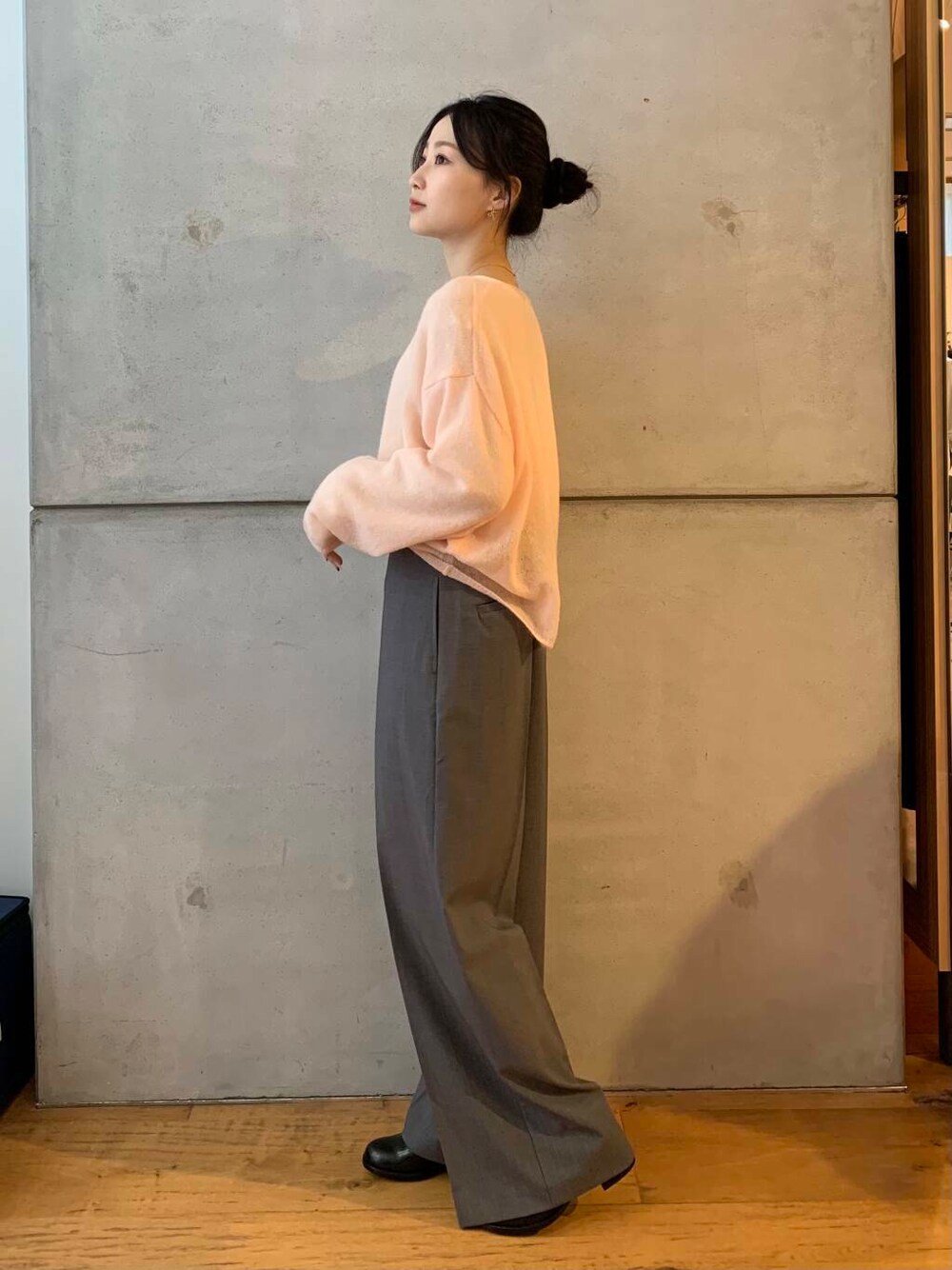 グレー系のその他パンツ、ブラック系のレインシューズ、ピンク系のニット/セーターを着用したレディースの秋コーディネートの5枚目の写真