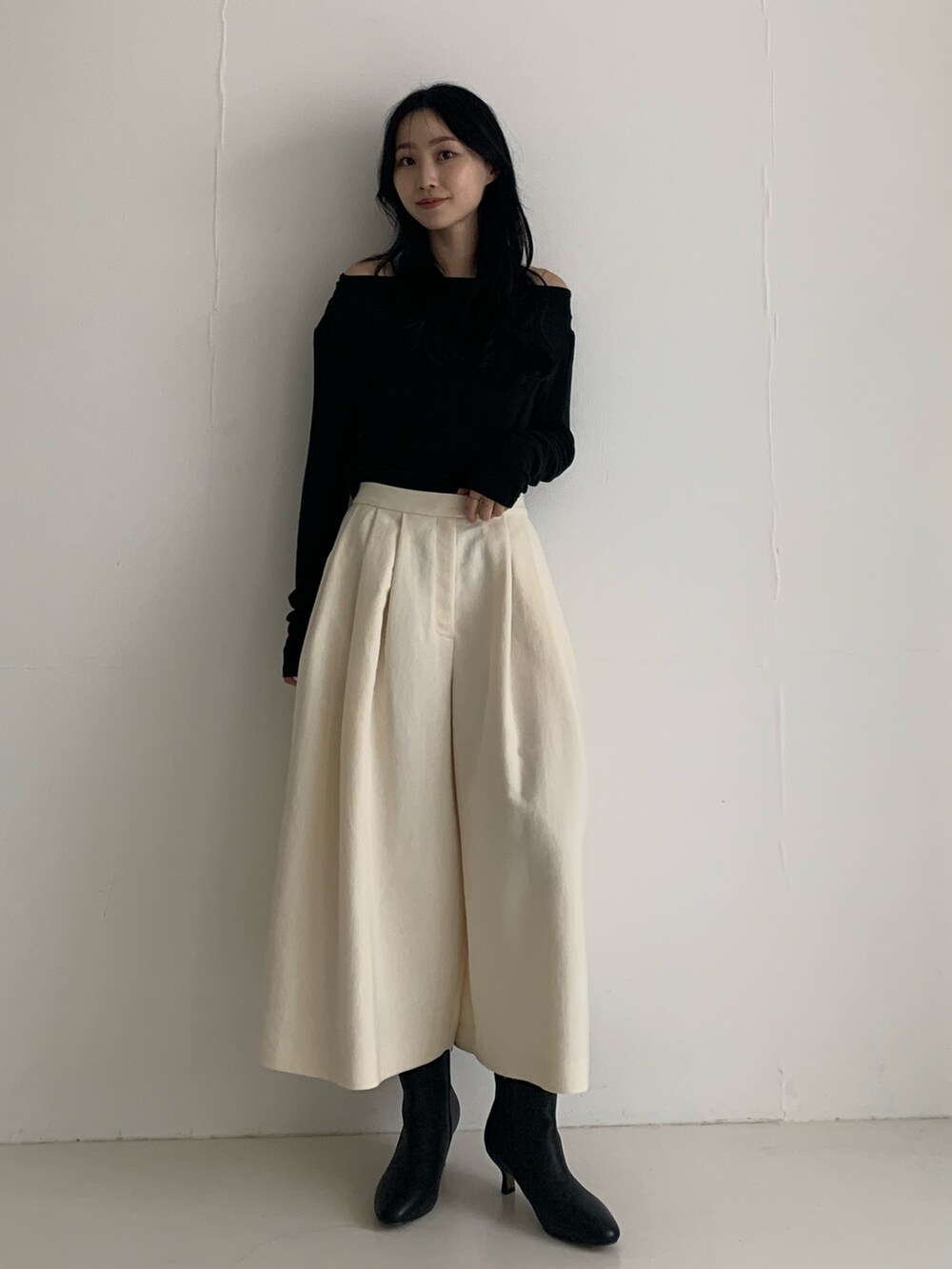 ブラック系のTシャツ/カットソー、ホワイト系のその他パンツ、ブラック系のブーツを着用したレディースの秋コーディネートの2枚目の写真