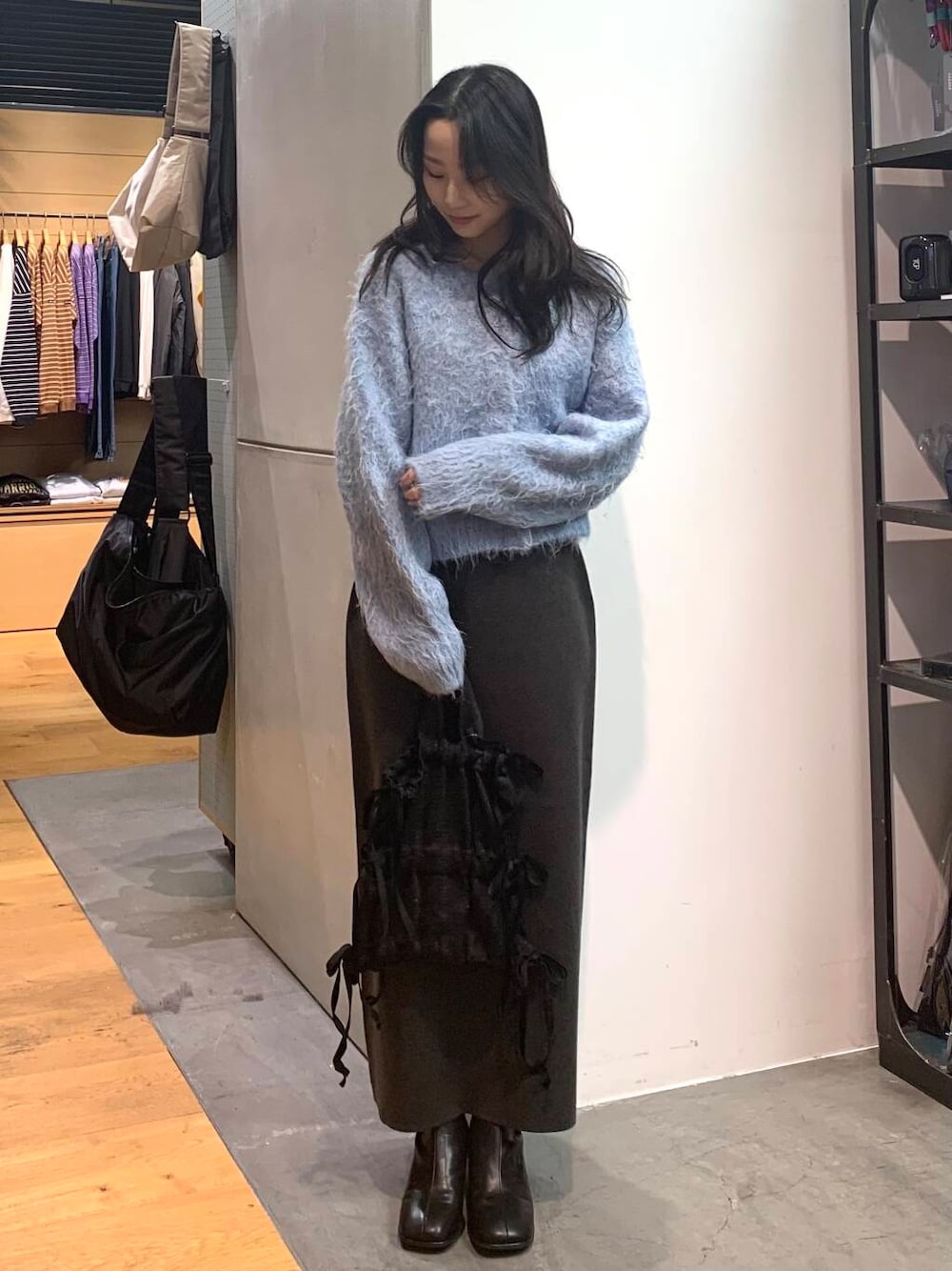 ブラック系のブーツ、グレー系のスカート、ブルー系のカーディガン/ボレロを着用したレディースの冬コーディネートの4枚目の写真