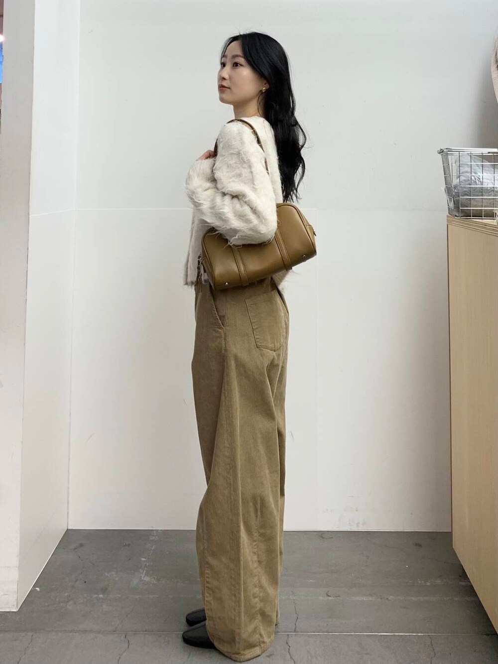 ブラック系のブーツ、グリーン系のボストンバッグ、ベージュ系のその他パンツを着用したレディースの冬コーディネートの6枚目の写真