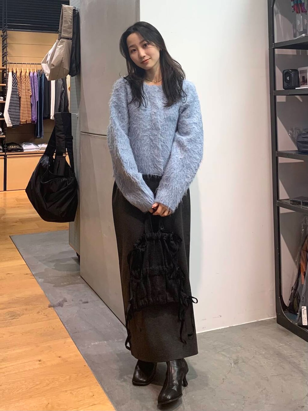 ブラック系のブーツ、グレー系のスカート、ブルー系のカーディガン/ボレロを着用したレディースの冬コーディネートの2枚目の写真