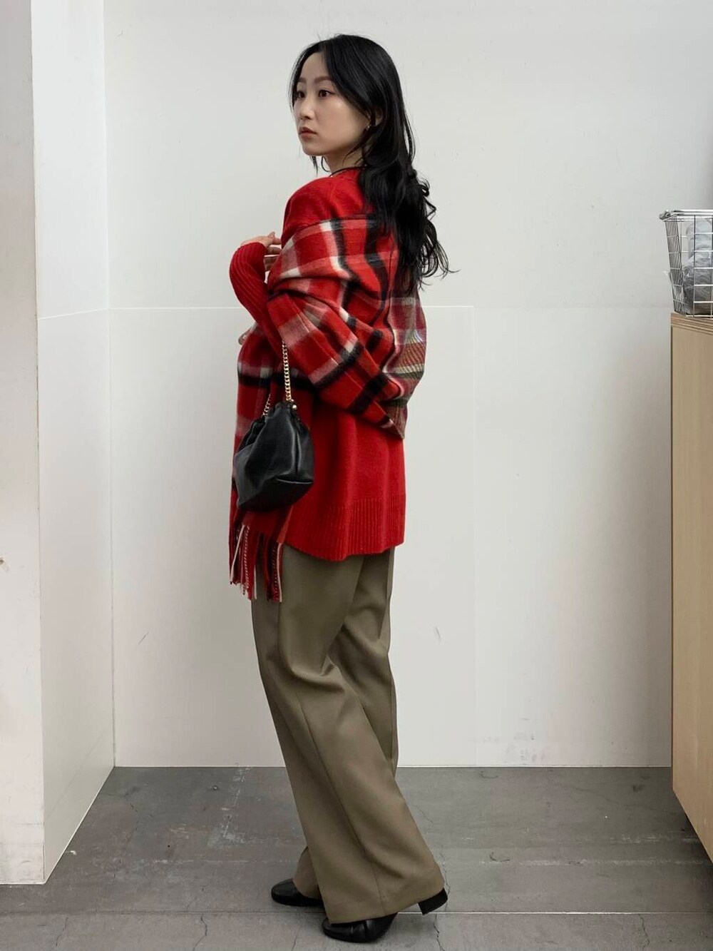 ブラック系のブーツ、レッド系のニット/セーター、ベージュ系のその他パンツを着用したレディースの冬コーディネートの4枚目の写真