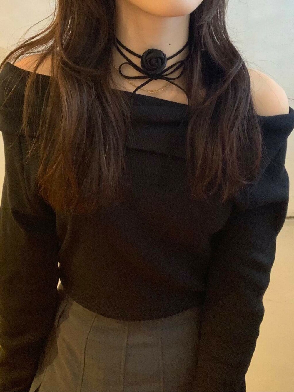 グレー系のスカート、ブラック系のブーツ、ブラック系のTシャツ/カットソーを着用したレディースの秋コーディネートの3枚目の写真