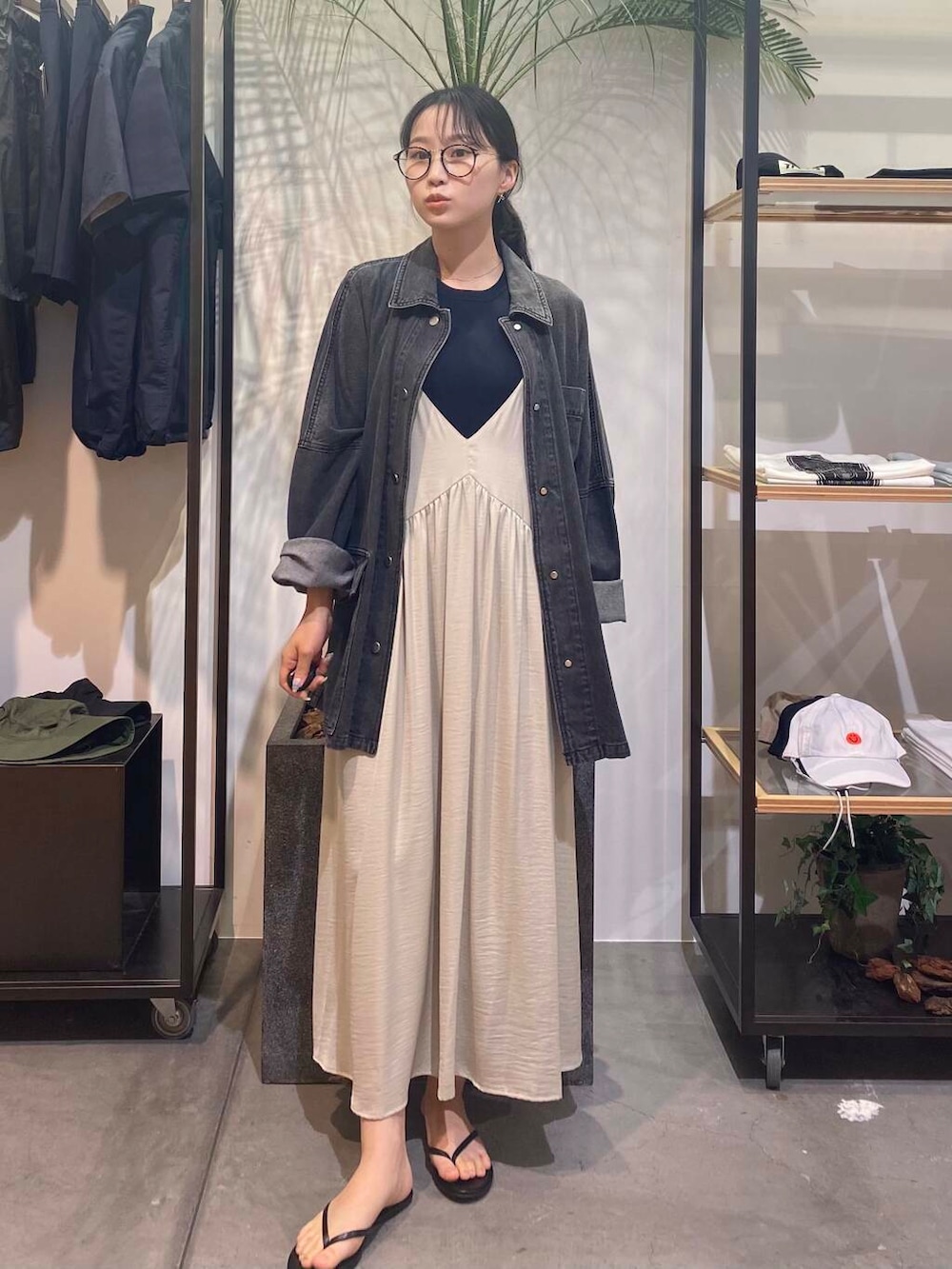 グリーン系のワンピース、ブラック系のサンダル、ブルー系のタンクトップを着用したレディースの夏コーディネートの2枚目の写真