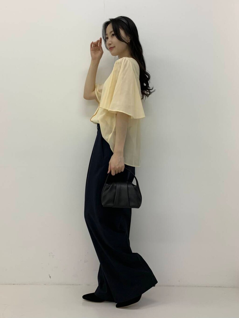 ブラック系のパンプス、ブラック系のハンドバッグ、ブルー系のその他パンツを着用したレディースの春コーディネートの4枚目の写真