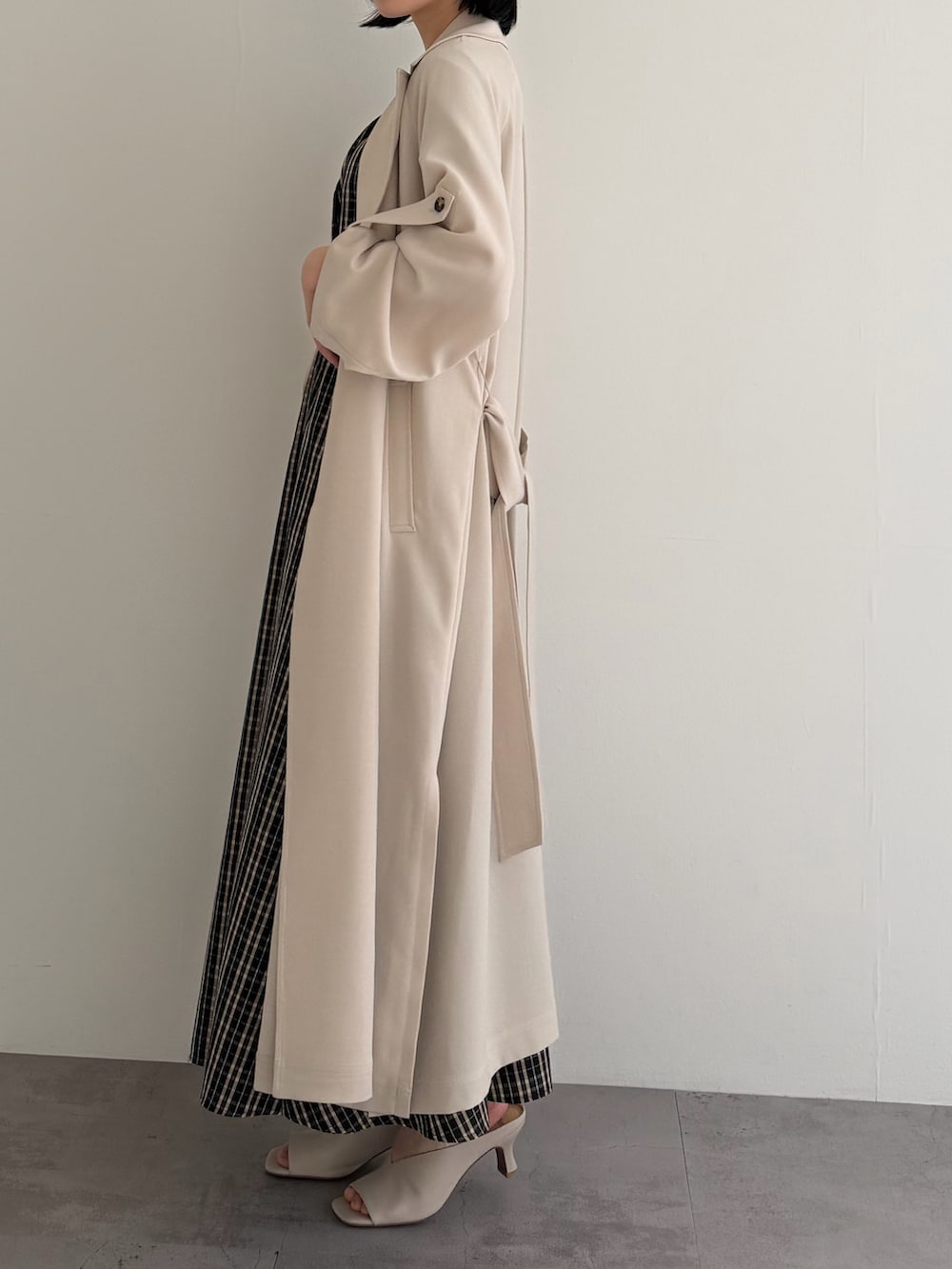 ブラウン系のワンピース、ベージュ系のトレンチコートを着用したレディースの春コーディネートの3枚目の写真