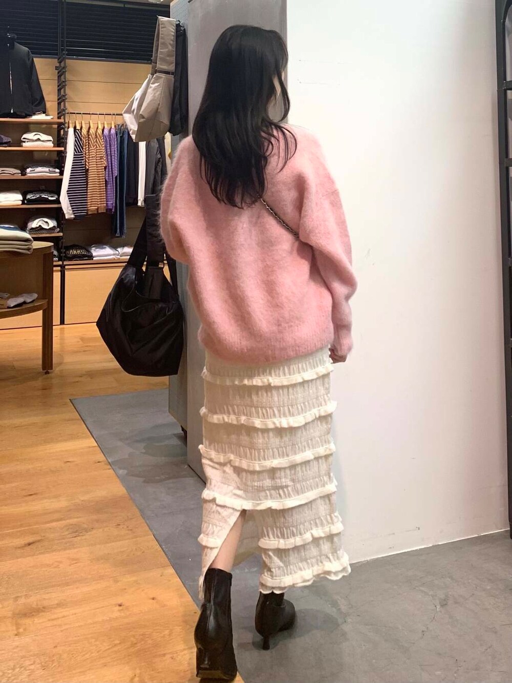 ブラック系のショルダーバッグ、ブラック系のブーツ、ピンク系のニット/セーターを着用したレディースの冬コーディネートの6枚目の写真