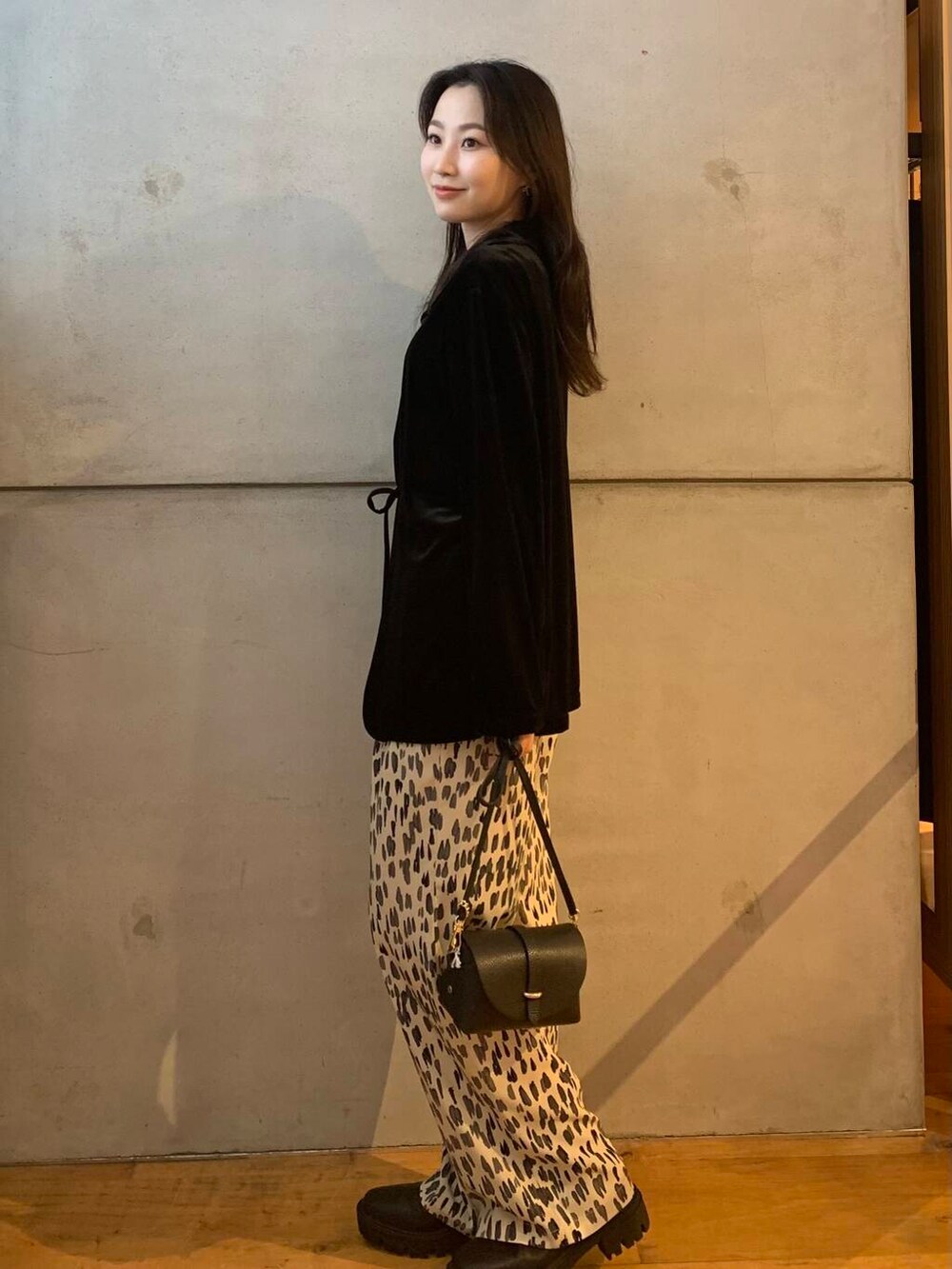 ブラック系のショルダーバッグ、ホワイト系のその他パンツ、ブラック系のブーツを着用したレディースの秋コーディネートの5枚目の写真