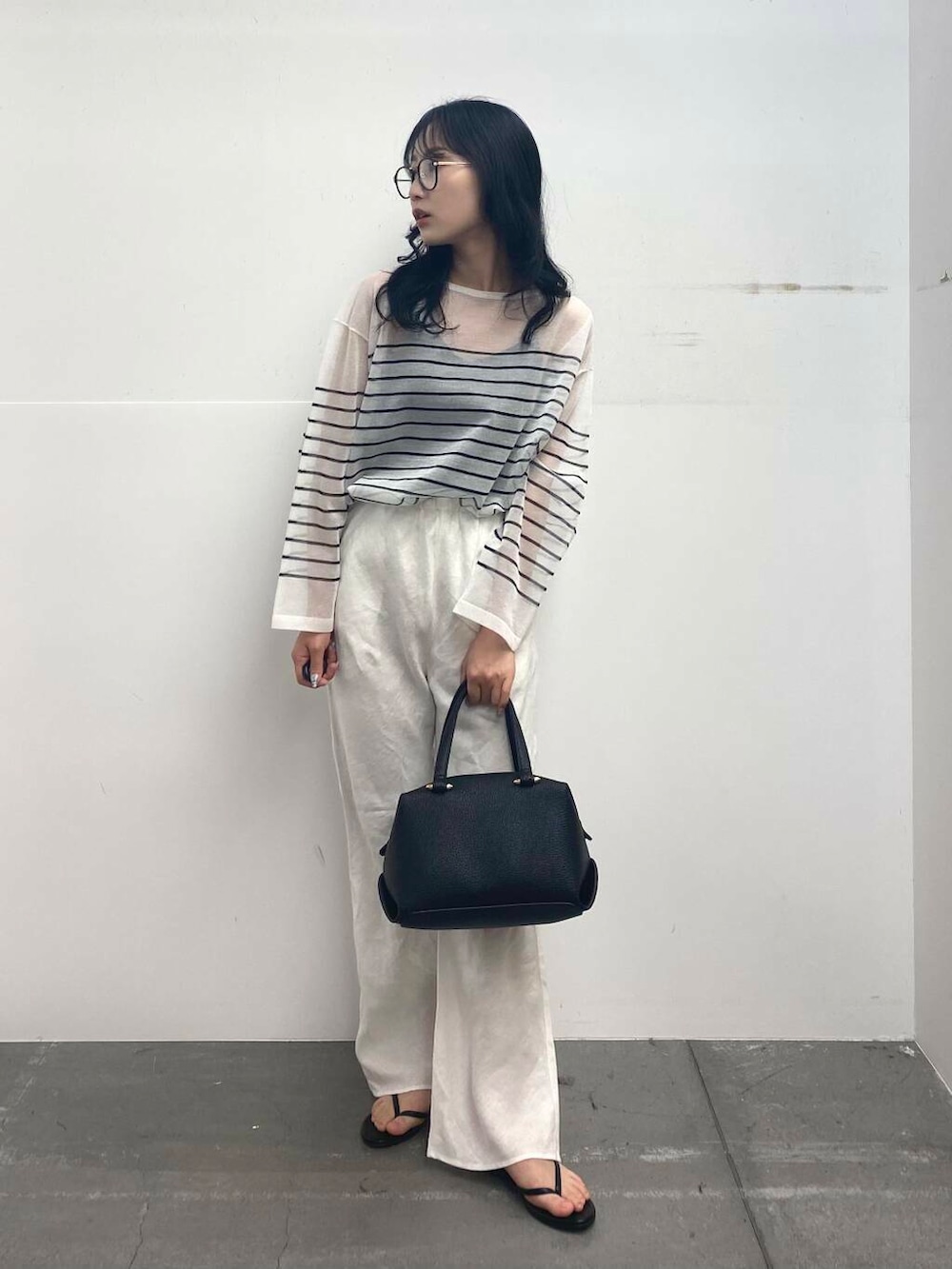 ブラック系のサンダル、ブラック系のハンドバッグ、ホワイト系のその他パンツを着用したレディースの夏コーディネートの4枚目の写真