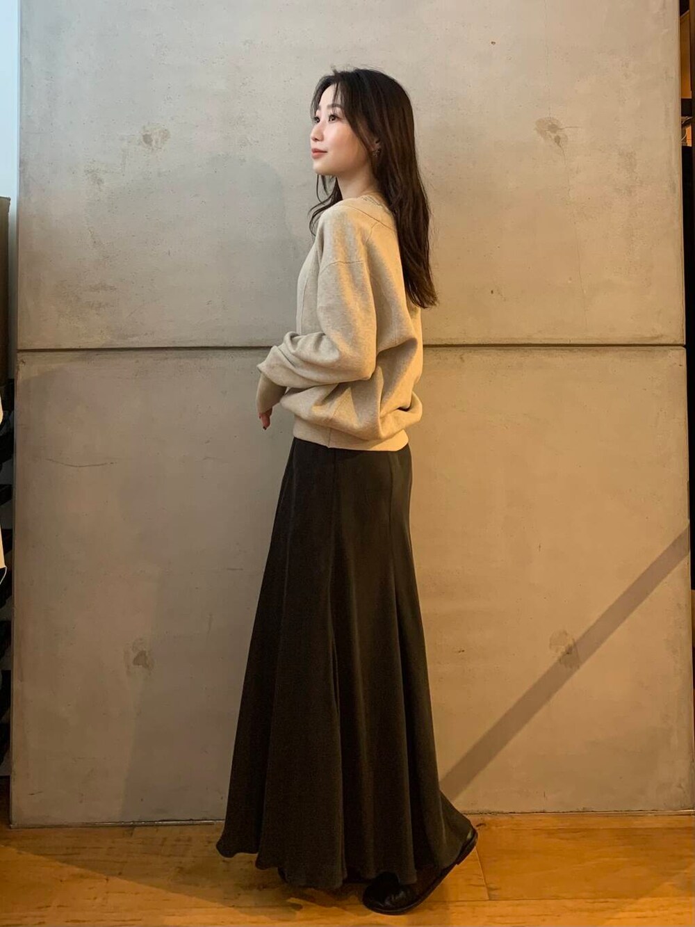 グレー系のスカート、ベージュ系のタンクトップ、ベージュ系のニット/セーターを着用したレディースの秋コーディネートの6枚目の写真