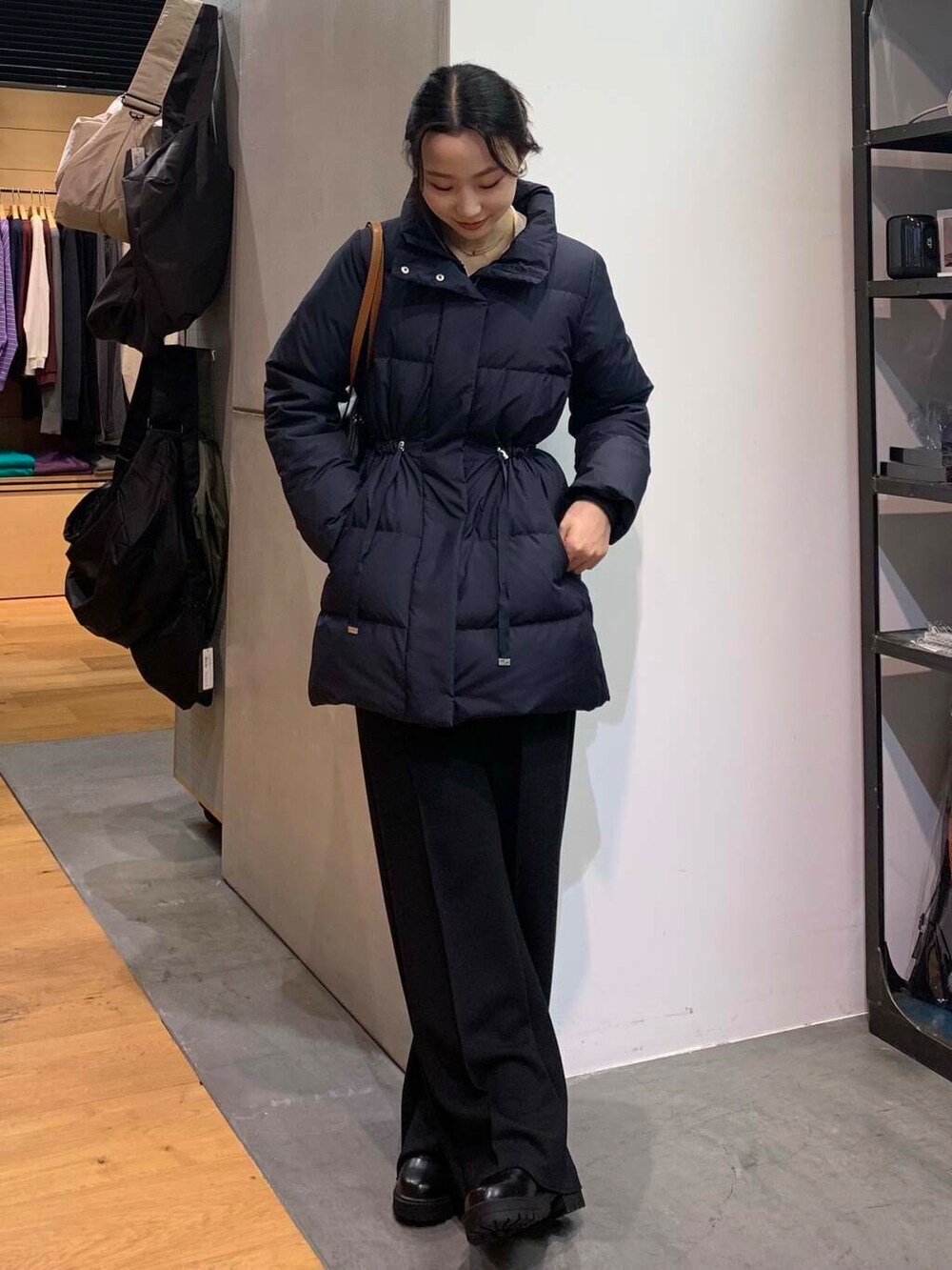 ブラック系のブーツ、ブラック系のその他パンツ、ブラック系のボストンバッグを着用したレディースの冬コーディネートの3枚目の写真