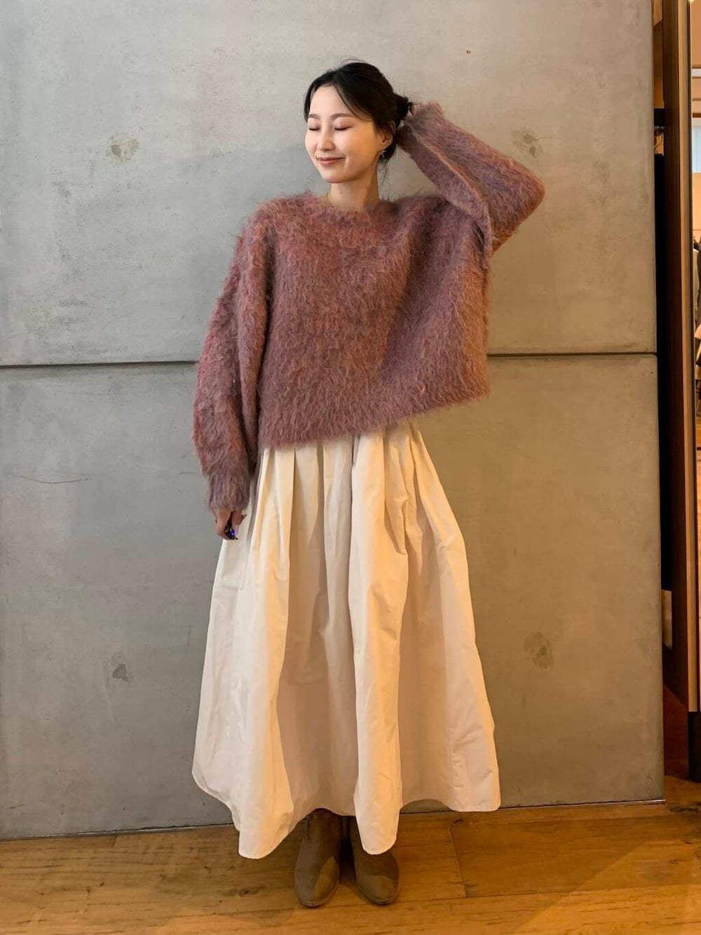 ピンク系のニット/セーター、ホワイト系のスカートを着用したレディースの秋コーディネートの5枚目の写真