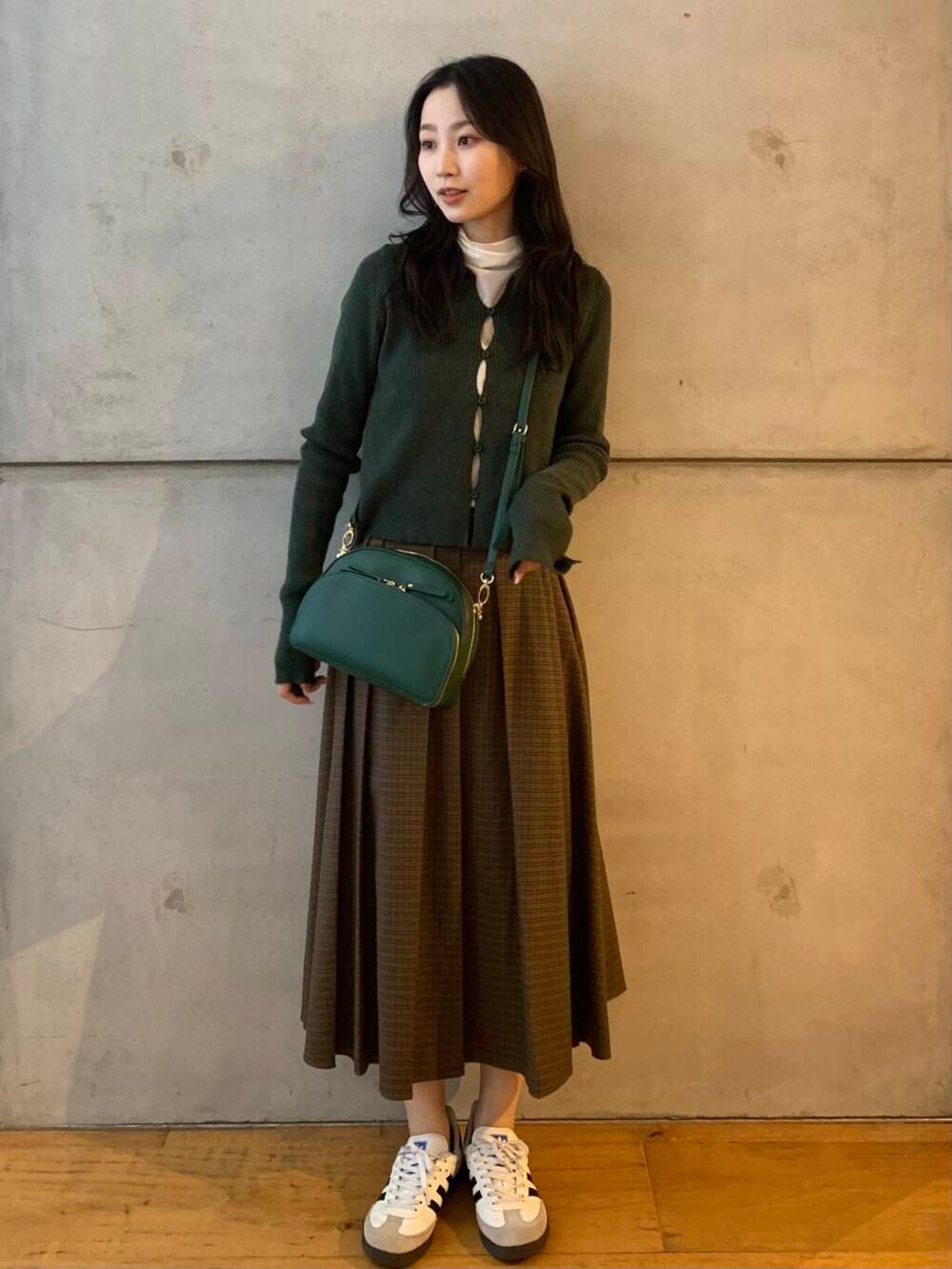 ホワイト系のTシャツ/カットソー、グリーン系のショルダーバッグ、ホワイト系のスニーカーを着用したレディースの秋コーディネートの3枚目の写真