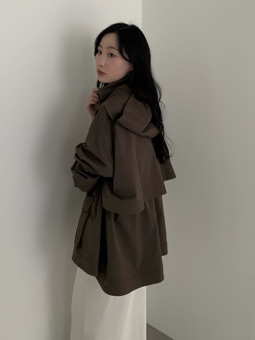 ブラウン系のマウンテンパーカーを着用したレディースの春コーディネートの2枚目の写真