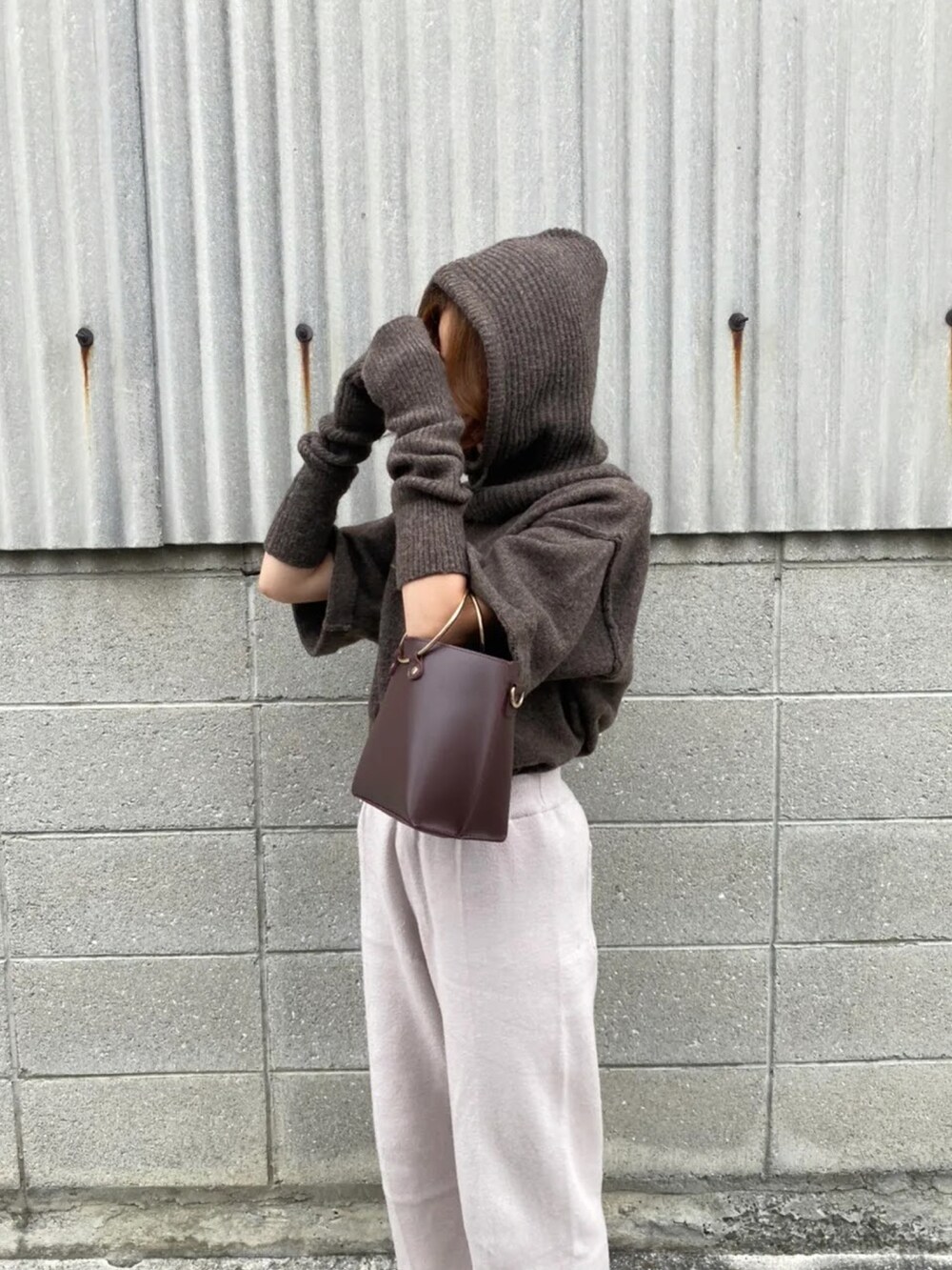 ブラウン系のニット/セーター、グレー系のその他パンツを着用したレディースの秋コーディネートの2枚目の写真