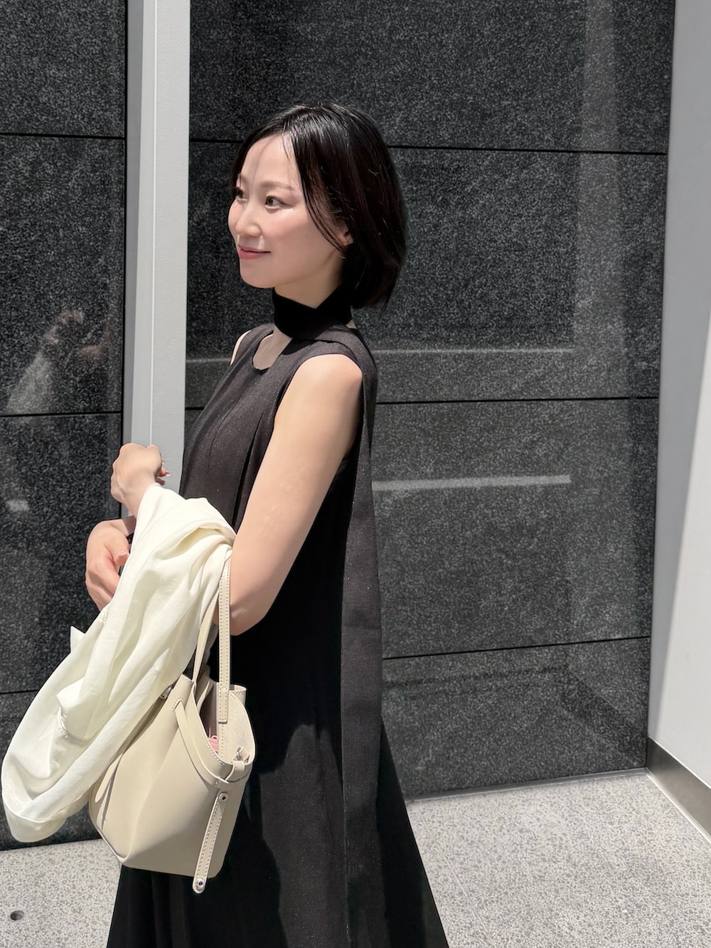 ブラック系のワンピース、ホワイト系のシャツ/ブラウスを着用したレディースの夏コーディネートの2枚目の写真