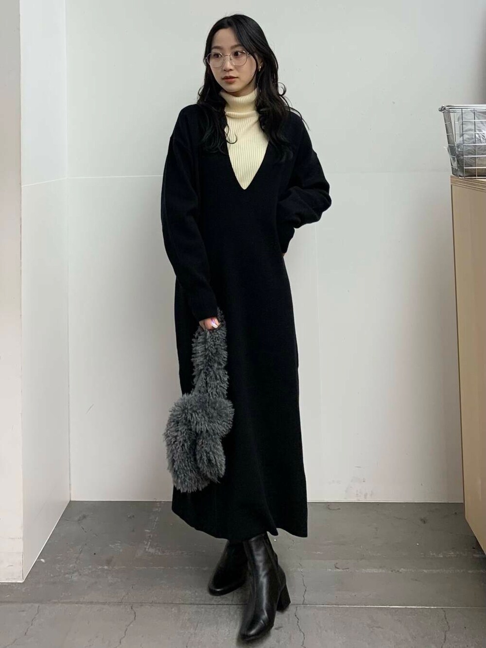 ブラック系のブーツ、グレー系のハンドバッグ、ホワイト系のニット/セーターを着用したレディースの冬コーディネートの4枚目の写真