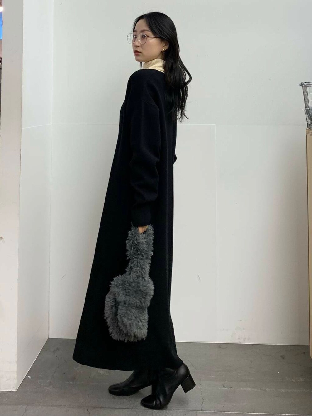 ブラック系のブーツ、グレー系のハンドバッグ、ホワイト系のニット/セーターを着用したレディースの冬コーディネートの5枚目の写真