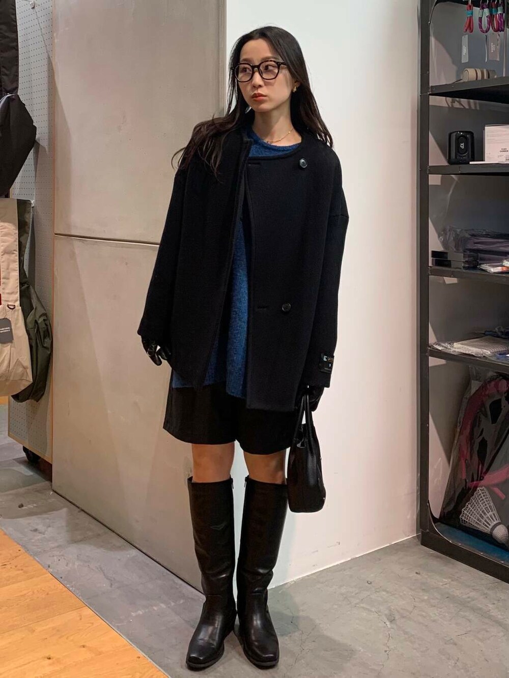 ブラック系のブーツ、ブラック系のその他パンツ、ブラック系のその他アウターを着用したレディースの冬コーディネートの7枚目の写真