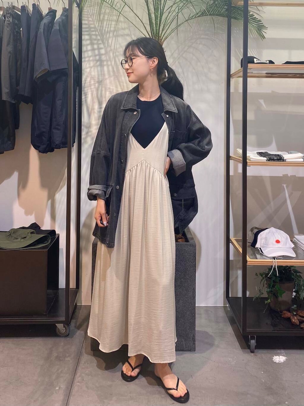 グリーン系のワンピース、ブラック系のサンダル、ブルー系のタンクトップを着用したレディースの夏コーディネートの3枚目の写真