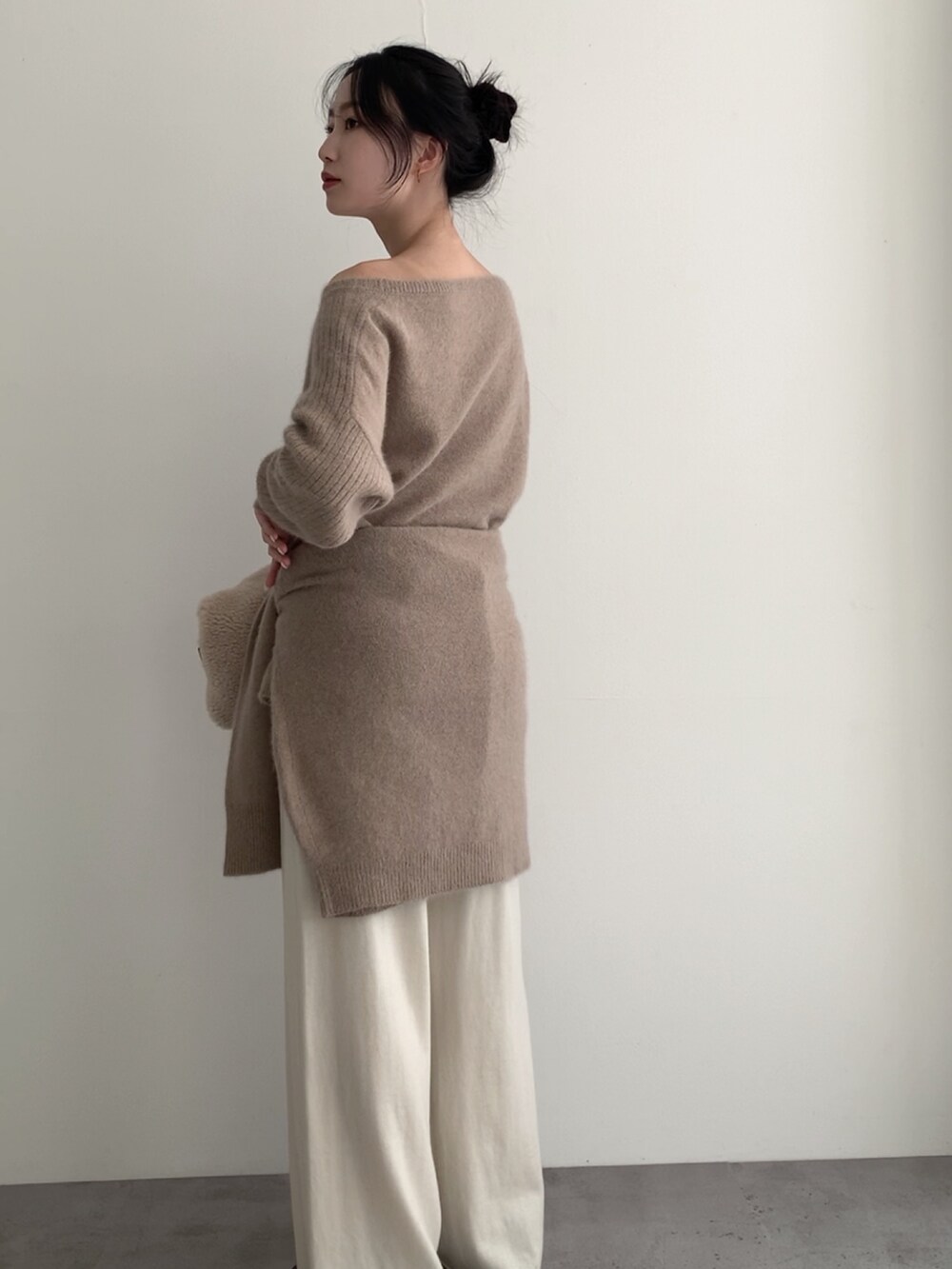 ベージュ系のニット/セーター、ホワイト系のその他パンツ、ベージュ系のカーディガン/ボレロを着用したレディースの冬コーディネートの4枚目の写真