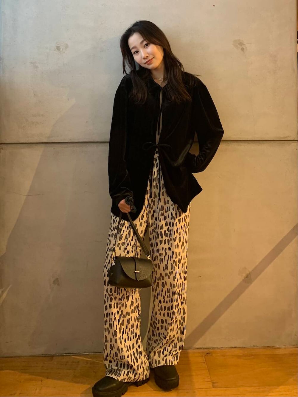 ブラック系のショルダーバッグ、ホワイト系のその他パンツ、ブラック系のブーツを着用したレディースの秋コーディネートの2枚目の写真