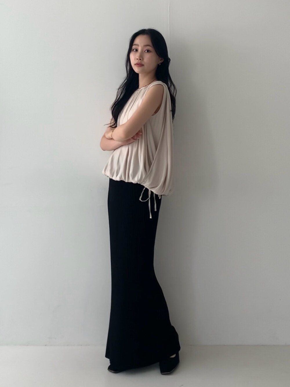 ホワイト系のシャツ/ブラウス、ブラック系のスカート、ブラック系のパンプスを着用したレディースの夏コーディネートの2枚目の写真