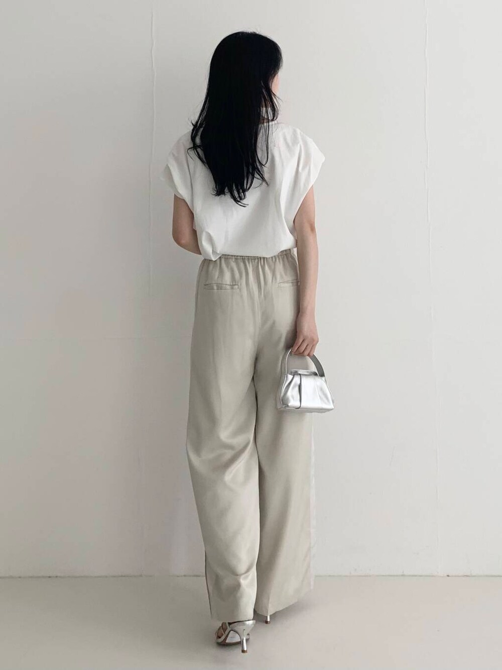 ベージュ系のその他パンツ、シルバー系のハンドバッグ、ホワイト系のTシャツ/カットソーを着用したレディースの春コーディネートの5枚目の写真