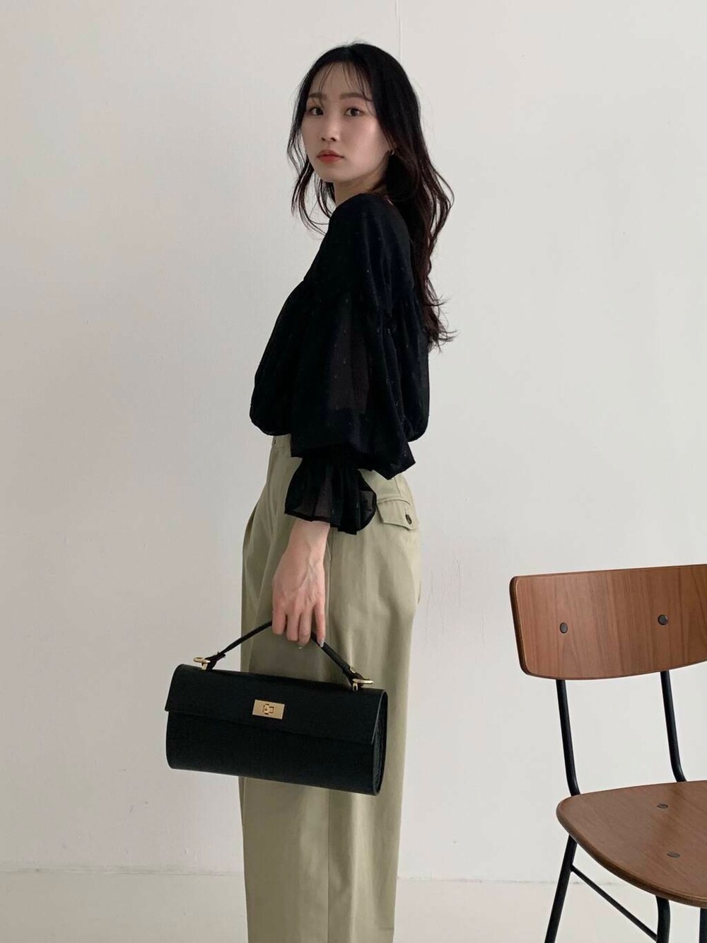 ブラック系のシャツ/ブラウス、ベージュ系のその他パンツ、ブラック系のショルダーバッグを着用したレディースの春コーディネートの2枚目の写真