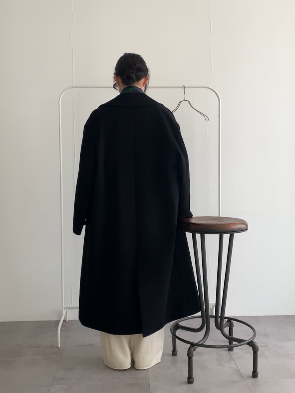 グレー系のニット/セーター、ホワイト系のその他パンツ、ブラック系のチェスターコートを着用したレディースの冬コーディネートの5枚目の写真