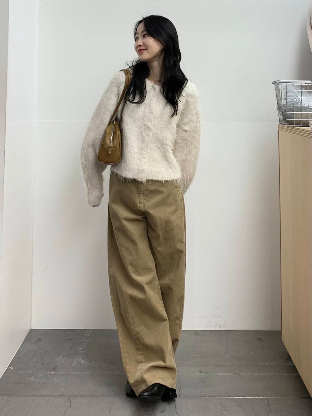 ブラック系のブーツ、グリーン系のボストンバッグ、ベージュ系のその他パンツを着用したレディースの冬コーディネートの3枚目の写真