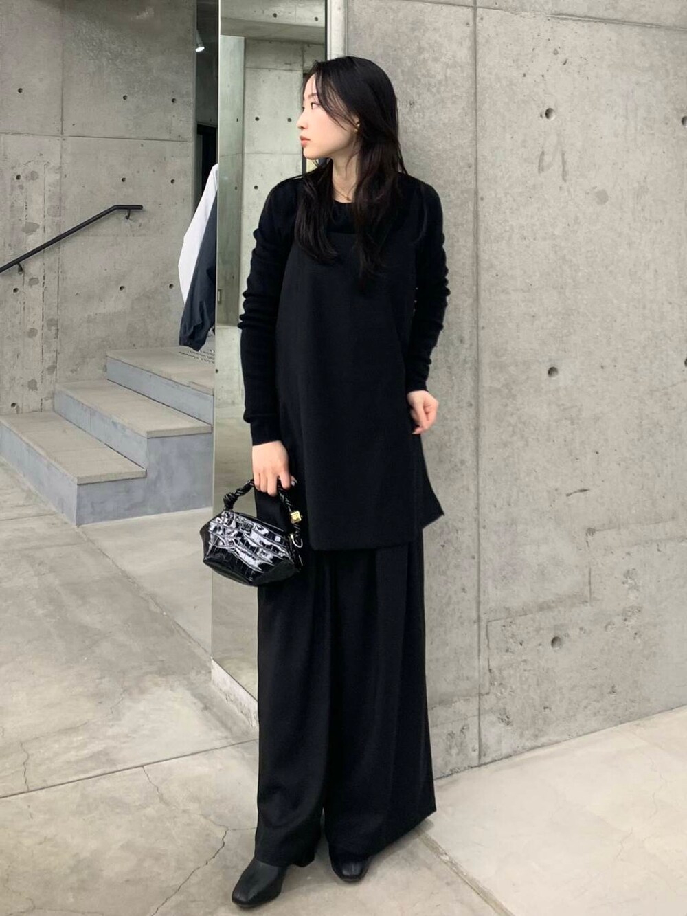ブラック系のブーツ、ブラック系のその他パンツ、ブラック系のショルダーバッグを着用したレディースの冬コーディネートの4枚目の写真