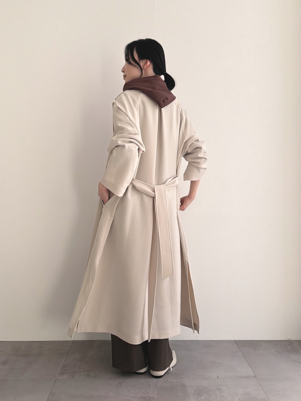 ベージュ系のトレンチコート、ブラウン系のパーカー、ブラウン系のその他パンツを着用したレディースの春コーディネートの4枚目の写真