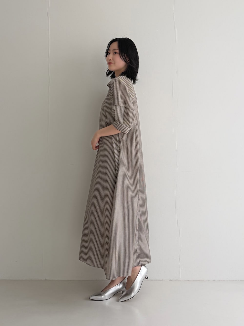 ブラウン系のワンピース、シルバー系のパンプスを着用したレディースの春コーディネートの5枚目の写真