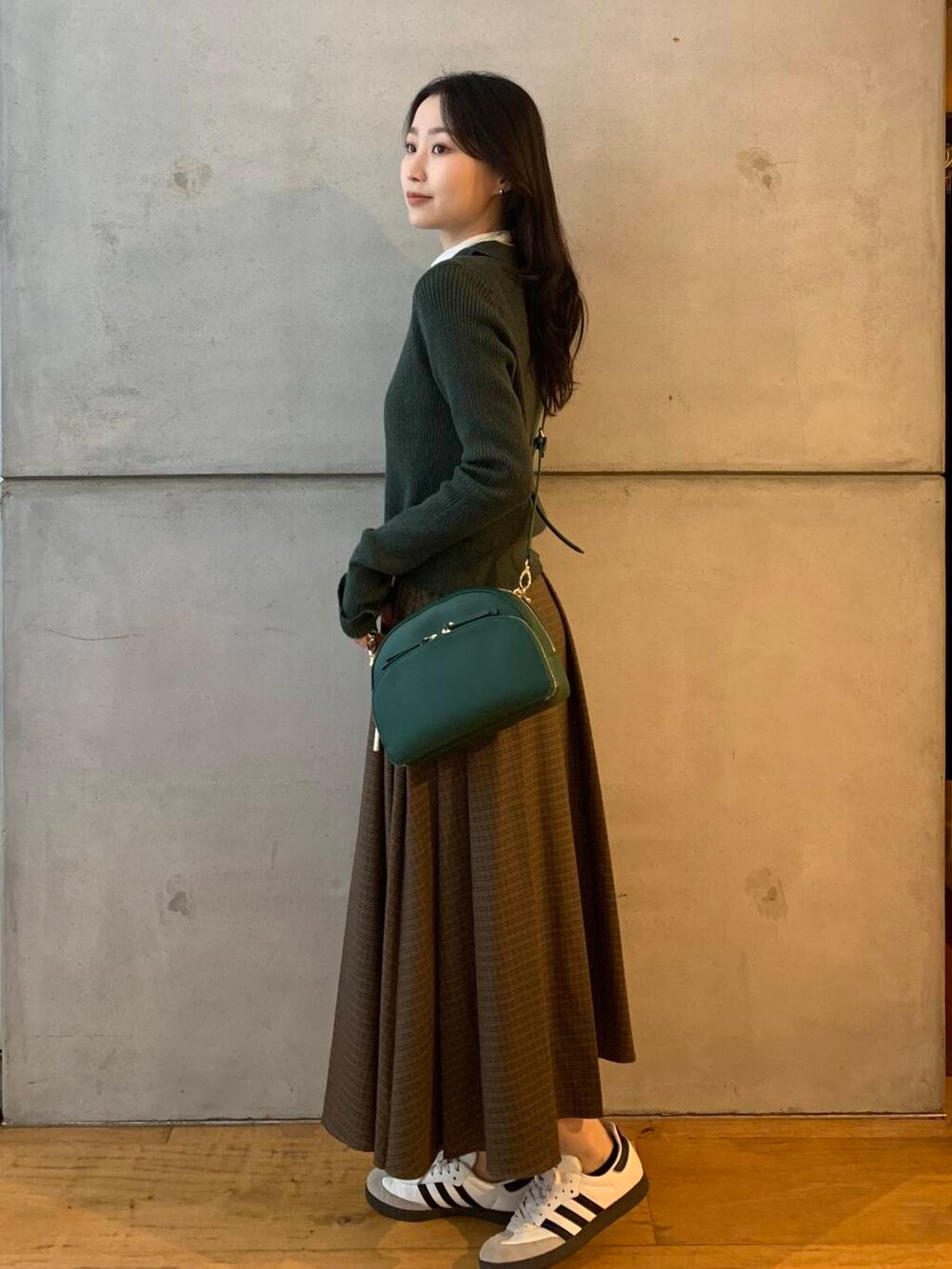 ホワイト系のTシャツ/カットソー、グリーン系のショルダーバッグ、ホワイト系のスニーカーを着用したレディースの秋コーディネートの4枚目の写真