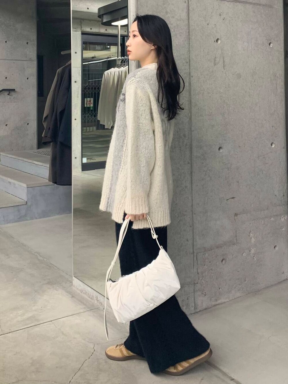 ブラック系のその他パンツ、グリーン系のニット/セーター、ホワイト系のショルダーバッグを着用したレディースの冬コーディネートの6枚目の写真