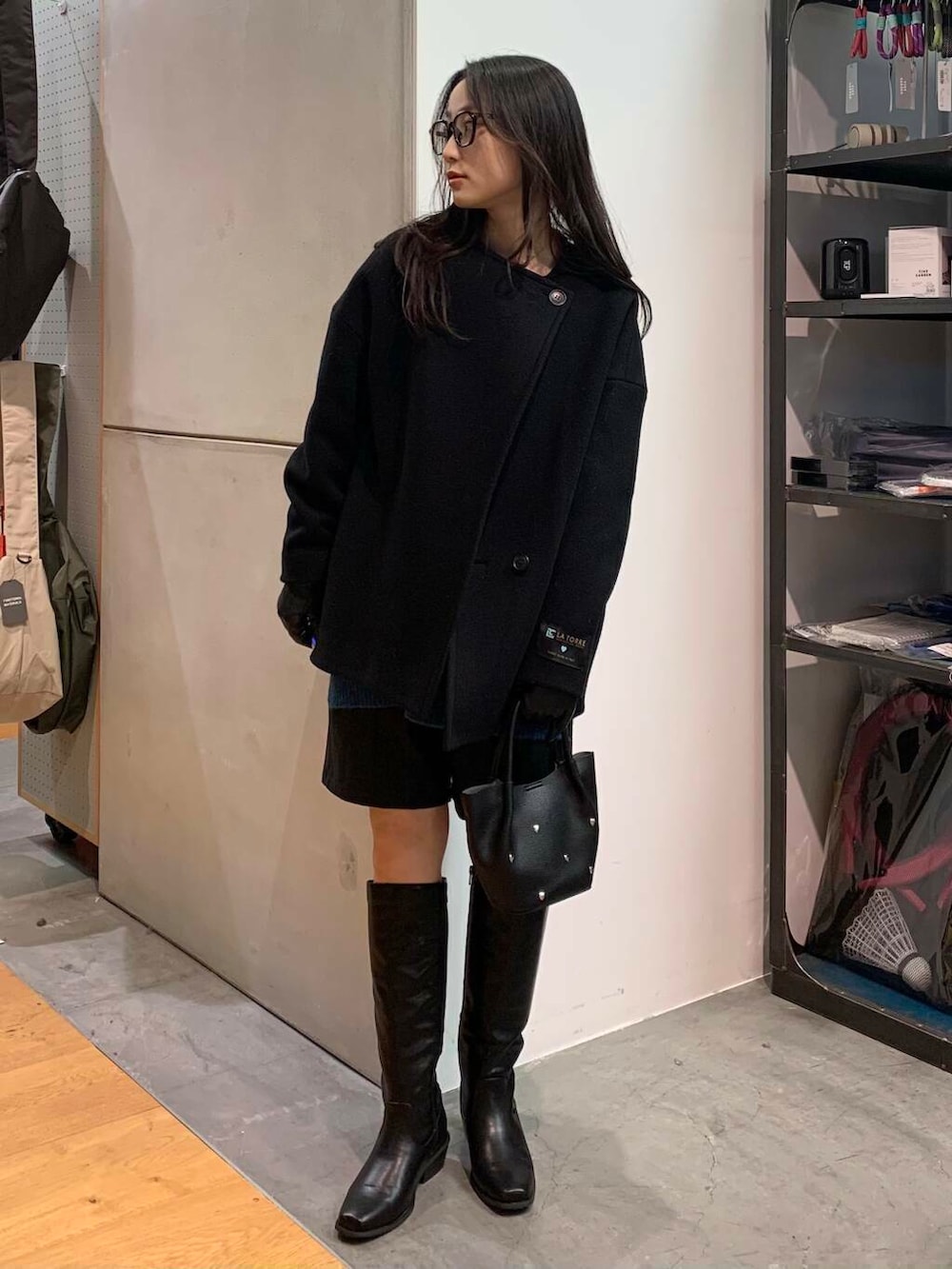 ブラック系のブーツ、ブラック系のその他パンツ、ブラック系のその他アウターを着用したレディースの冬コーディネートの8枚目の写真